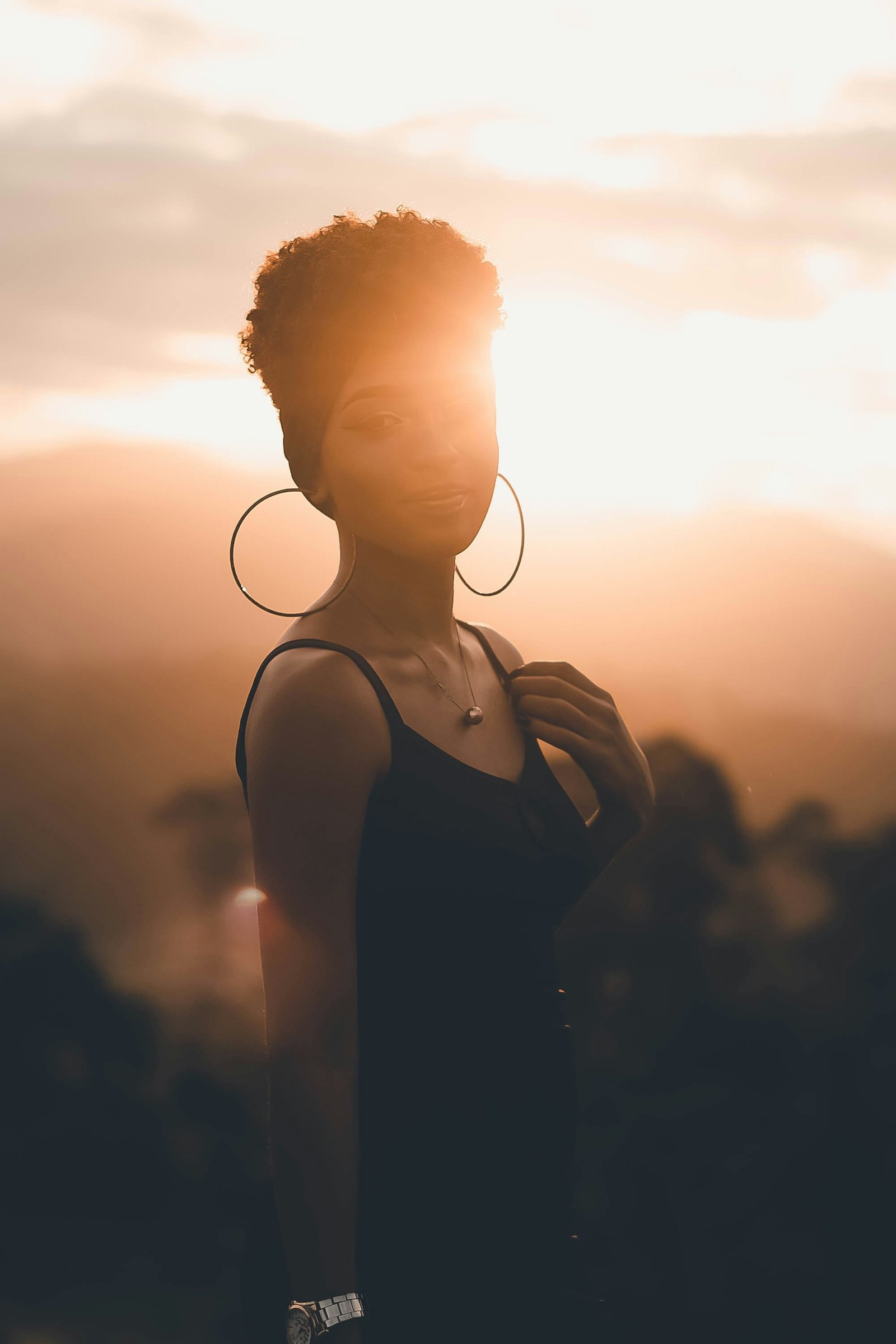 A young person standing calmly in warm evening light