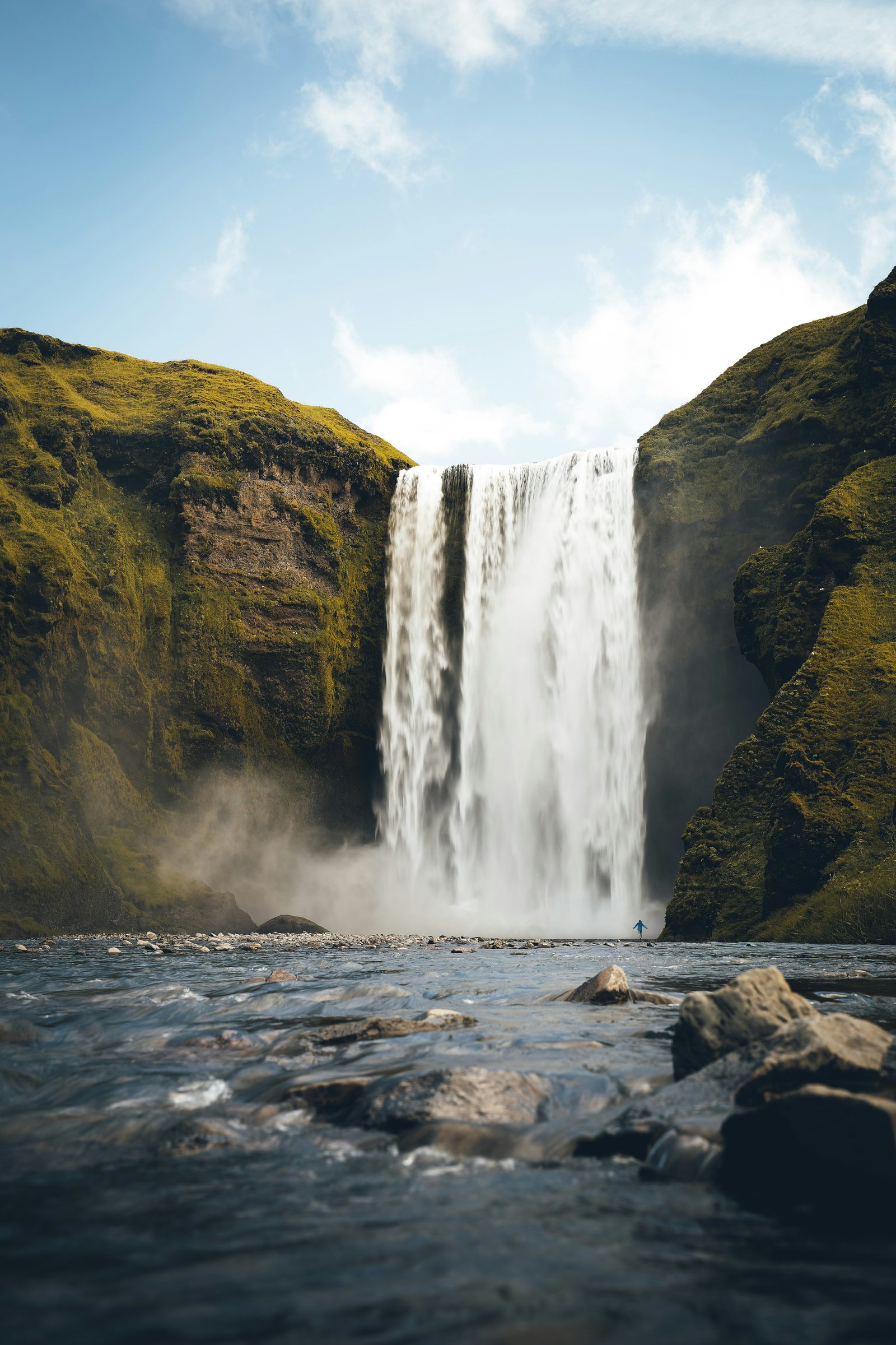 A waterfall with a small figure below it